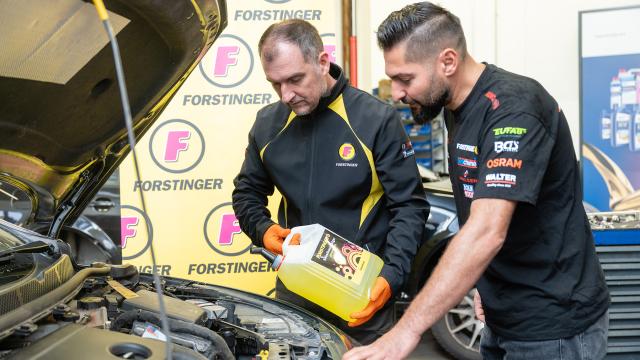 Mechaniker stehen bei offener Motorhaube