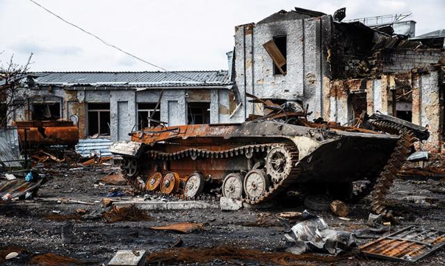 Ein zerstörter Panzer vor einem zerstörten Haus.