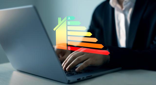 Mann vor Laptop mit Energieeffizienzklassen-Grafik