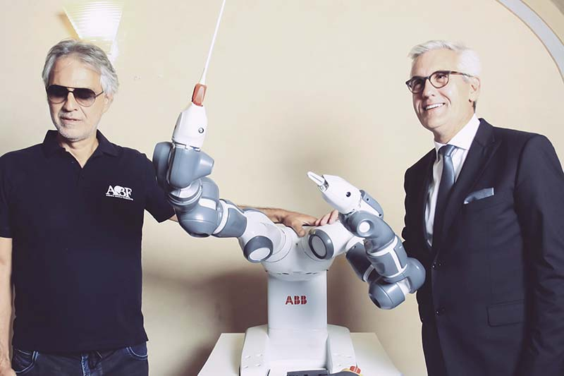 Foto: Tenor Andrea Bocelli und ABB-CEO Ulrich Spiesshofer nehmen den robotischen Dirigenten YuMi in die Mitte.