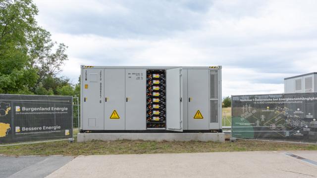 Stromspeicher in Einhausung steht auf einer Wiese